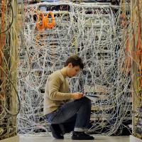 Ein Elektroniker überprüft Kabel für verschiedene Telekommunikationsnetze.